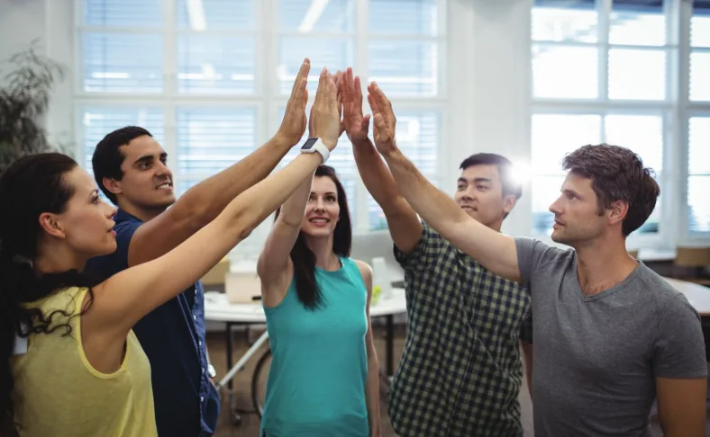 Grupo de personas celebrando juntas en un espacio de trabajo